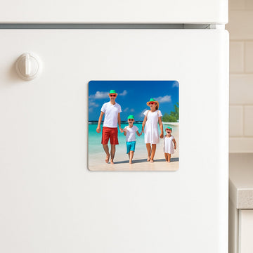 A bright kitchen fridge with a 3x3 photo magnet of a family beach vacation, showing the magnet’s vivid colors and glossy finish. Alt: 3x3 photo magnet on fridge displaying a beach photo.